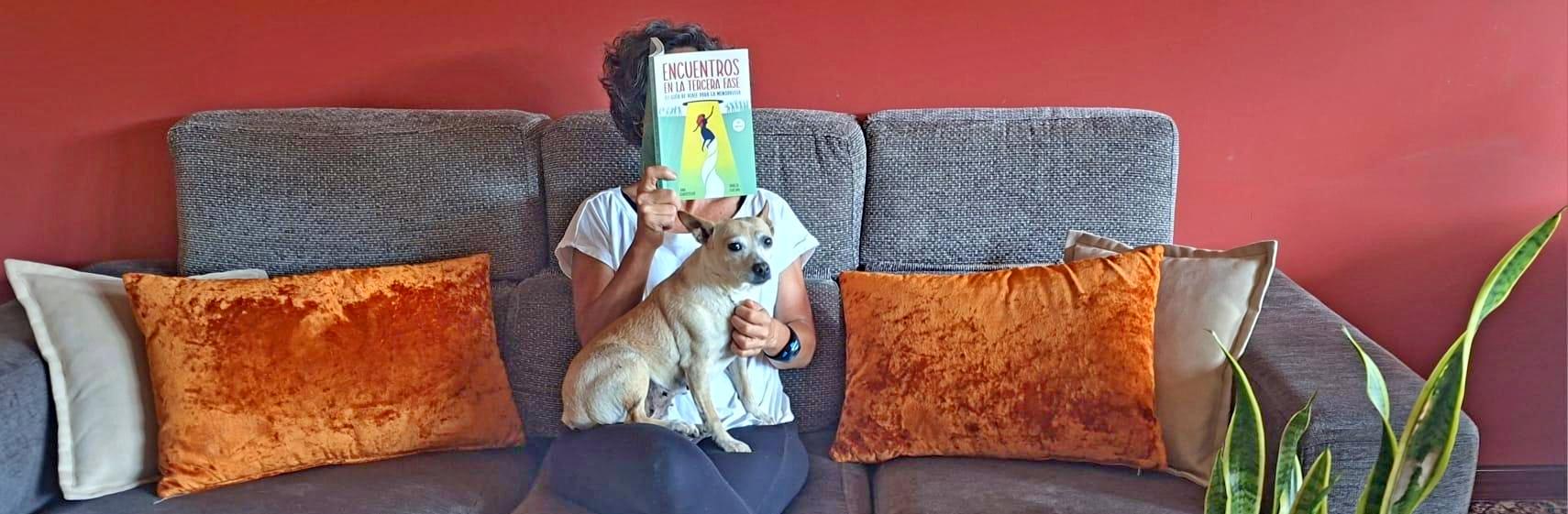 amelie leyendo libro sobre menopausia en el sofa